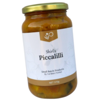 Traditional piccalilli with chunky vegetables in mustard and turmeric sauce, served in a jar.